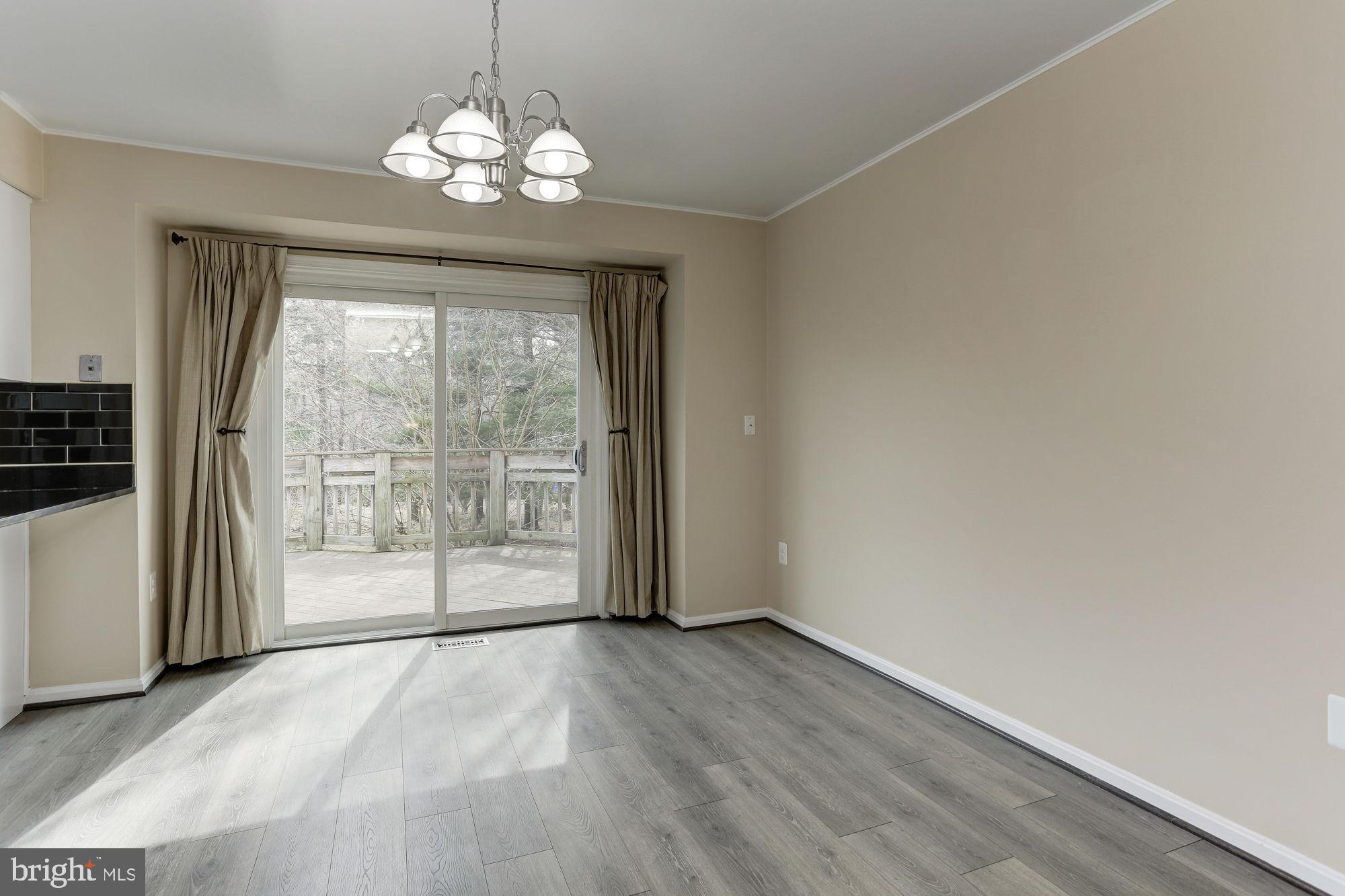 10107 Galsworthy Place Bethesda, MD 20817 - Photo 16 of 62 a view of a livingroom with wooden floor and a large window