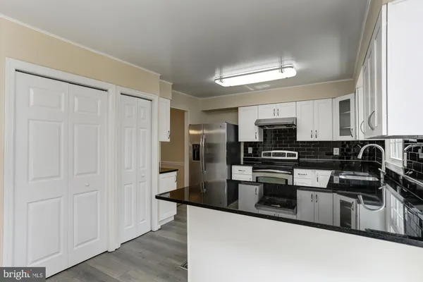 a kitchen with granite countertop a stove and a sink