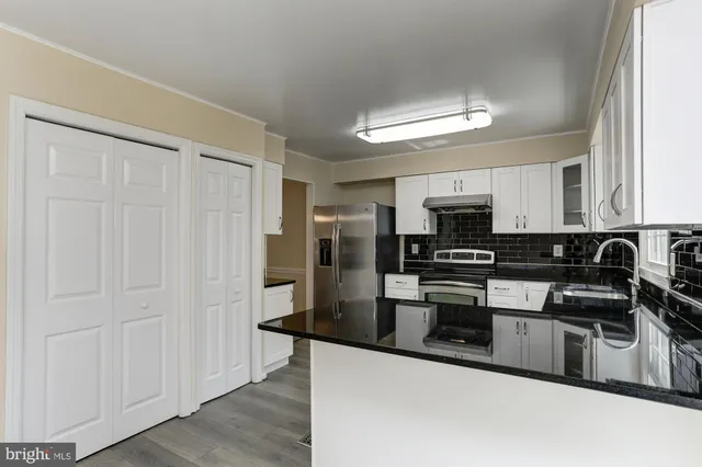 a kitchen with granite countertop a stove and a sink