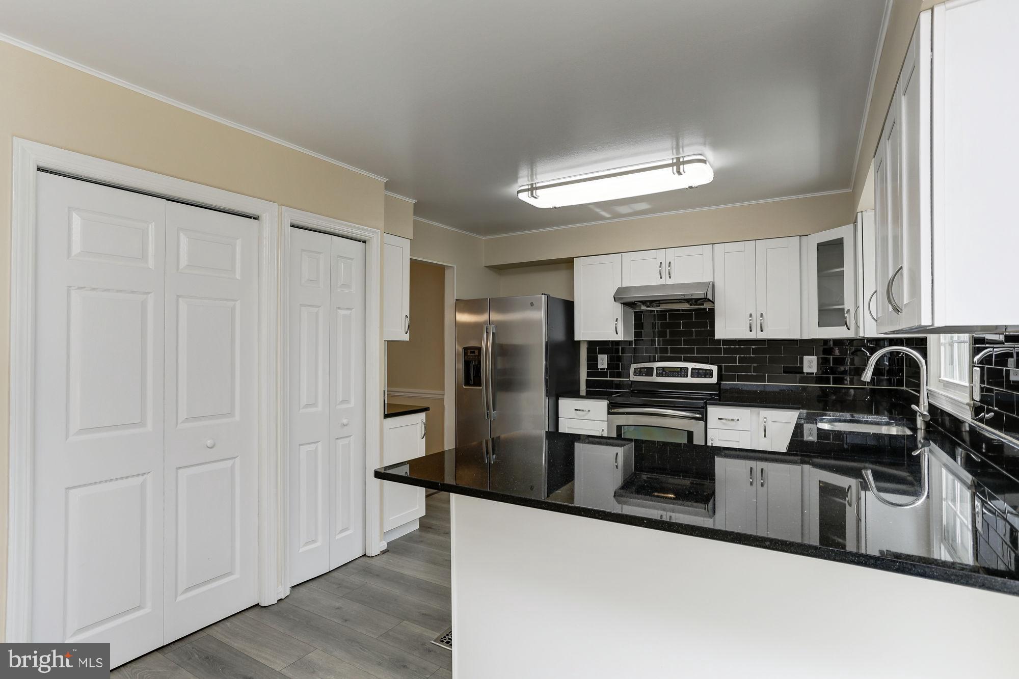 10107 Galsworthy Place Bethesda, MD 20817 - Photo 19 of 62 a kitchen with stainless steel appliances granite countertop a stove a sink and a refrigerator