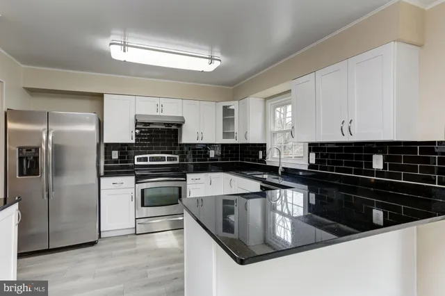 a kitchen with granite countertop a sink and cabinets