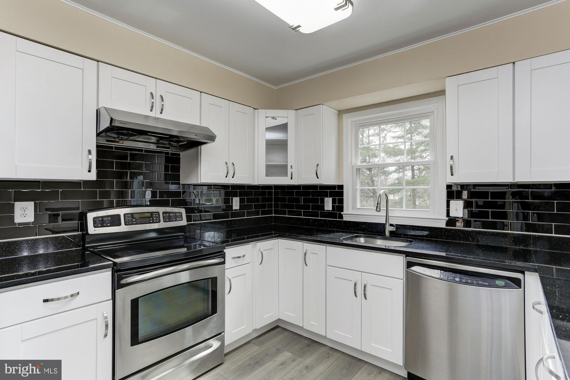 10107 Galsworthy Place Bethesda, MD 20817 - Photo 22 of 62 a kitchen with granite countertop a stove and a sink