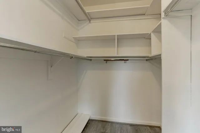 an empty room with wooden floor and closet area