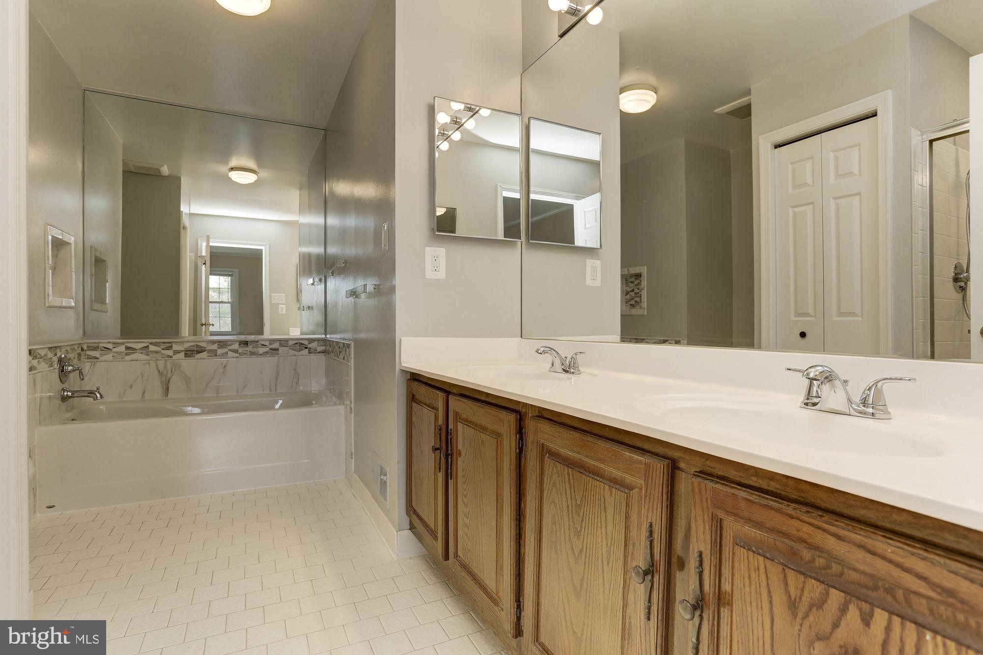 10107 Galsworthy Place Bethesda, MD 20817 - Photo 32 of 62 a bathroom with a bathtub shower sink and mirror