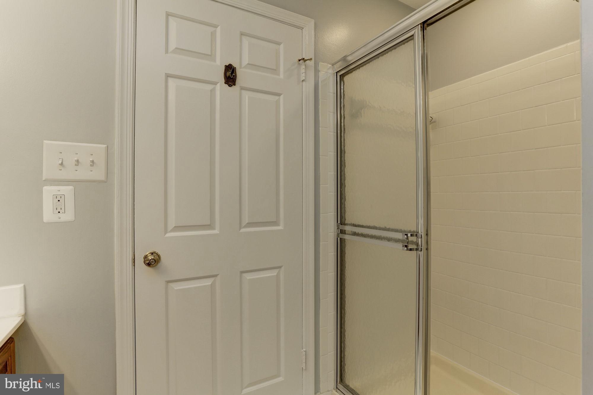 10107 Galsworthy Place Bethesda, MD 20817 - Photo 34 of 62 a bathroom with a glass shower door