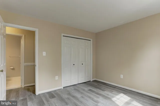 a view of an empty room with wooden floor and a fireplace