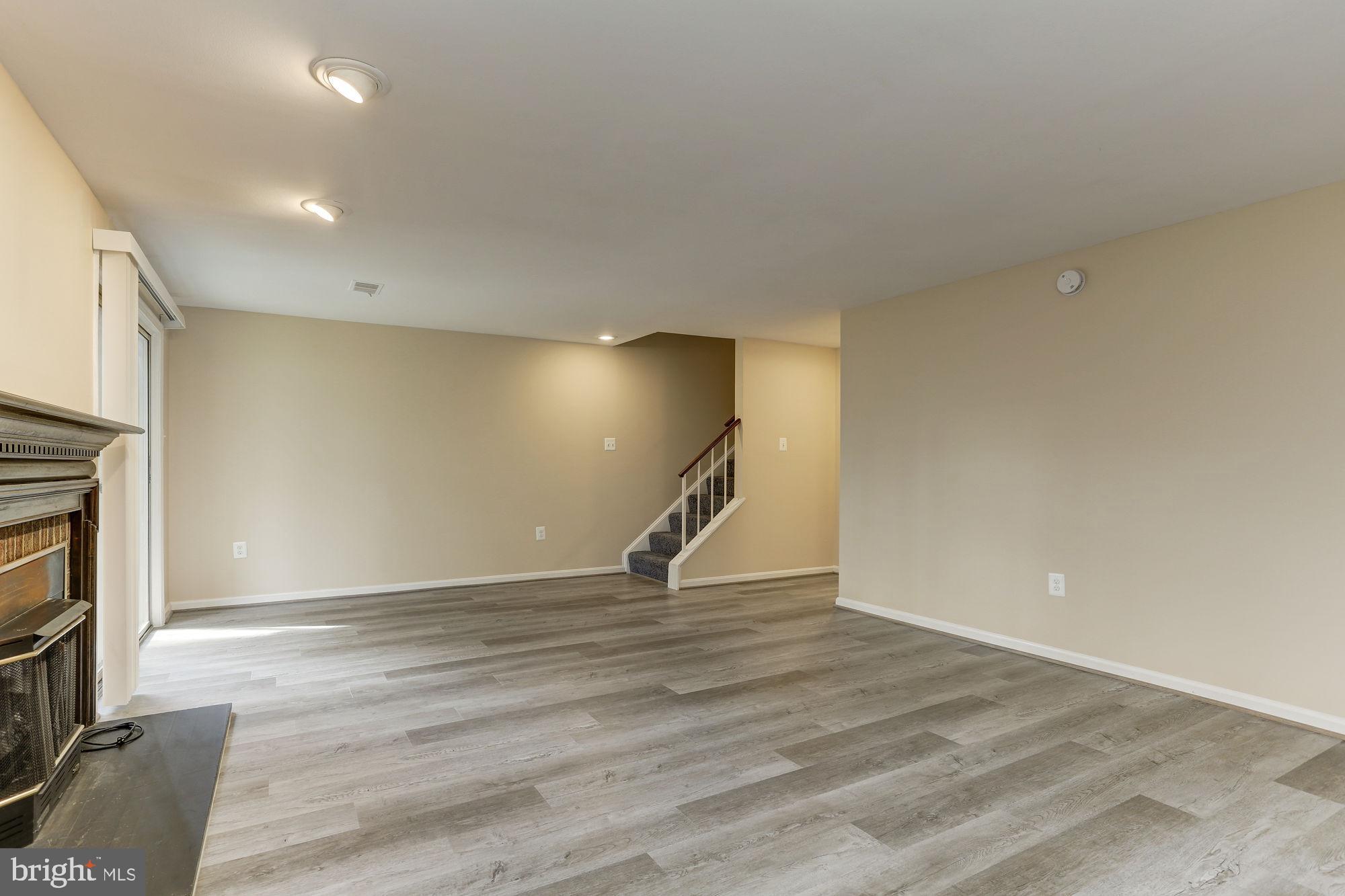 10107 Galsworthy Place Bethesda, MD 20817 - Photo 47 of 62 a view of an empty room with wooden floor and a fireplace