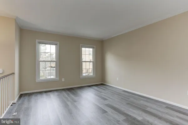 an empty room with wooden floor and window
