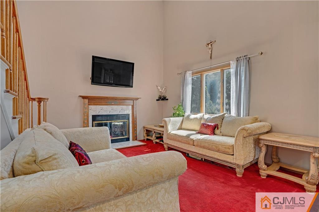 10 Crescent Road Edison, NJ 08817 - Photo 22 of 33 a living room with furniture a flat screen tv and a fireplace