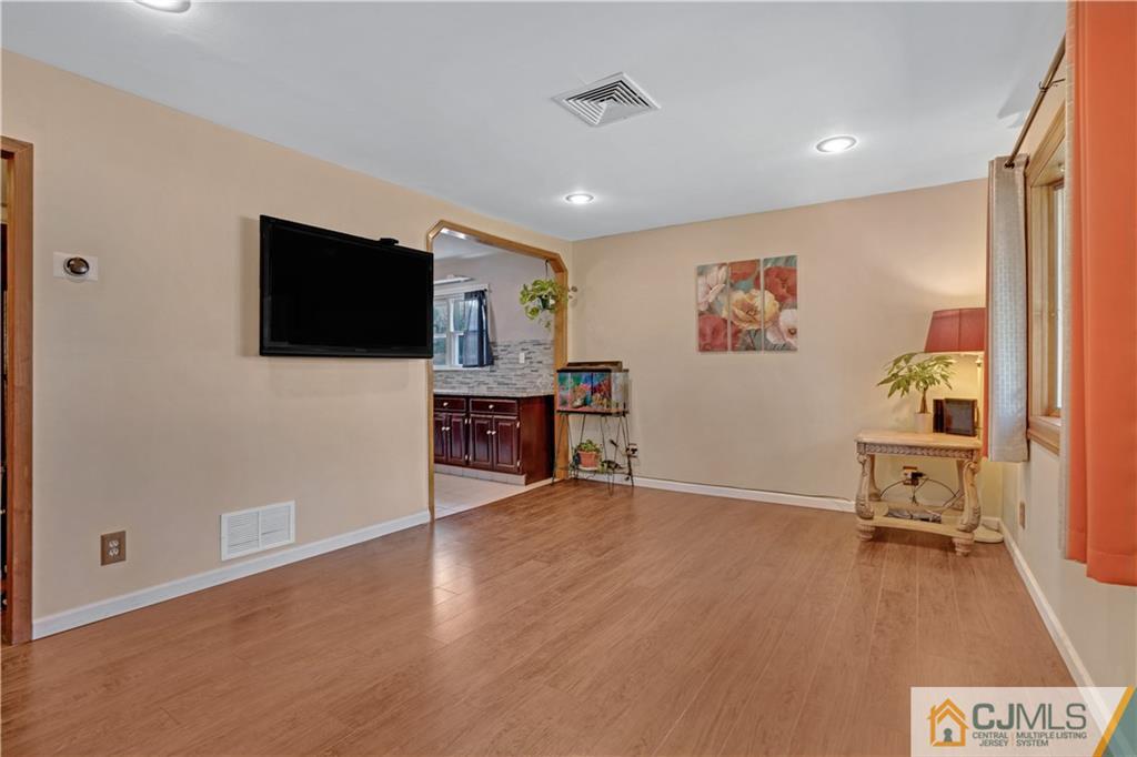 10 Crescent Road Edison, NJ 08817 - Photo 4 of 33 a view of a livingroom with wooden floor and a flat screen tv