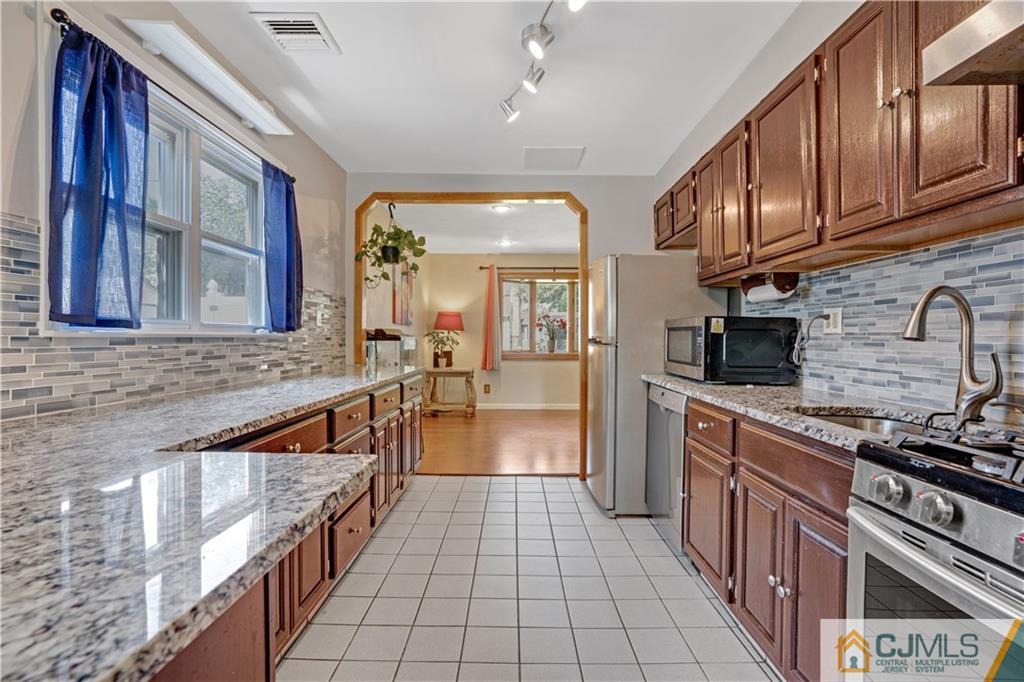 10 Crescent Road Edison, NJ 08817 - Photo 6 of 33 a kitchen with stainless steel appliances granite countertop a stove and cabinets