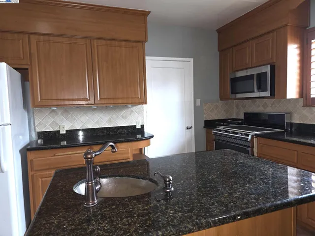 a kitchen with a sink a stove and cabinets