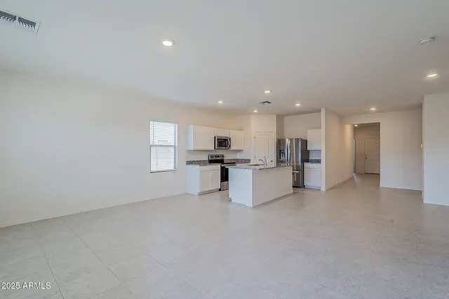 a view of kitchen with kitchen island white cabinets and refrigerator