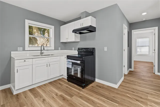 a kitchen with a sink dishwasher a stove and a window