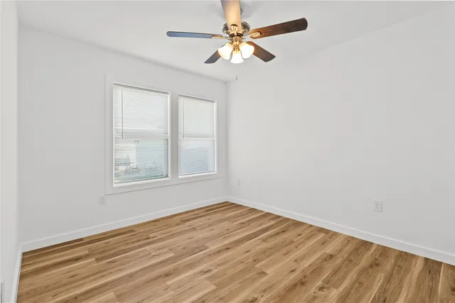 an empty room with a window and a fan