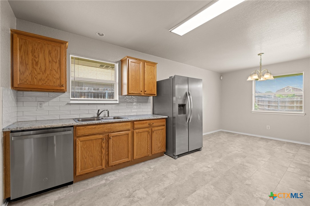 214 Timber Ridge Drive Nolanville, TX 76559 - Photo 12 of 31 a kitchen with stainless steel appliances granite countertop a refrigerator and a sink