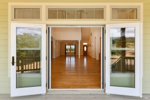 a view of a hallway with wooden floor and a living room