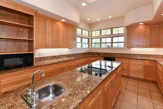 a kitchen with kitchen island a sink and a stove top oven