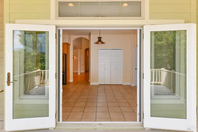 a view of a hallway with wooden floor and a living room