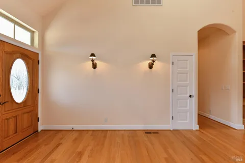 a kitchen with stainless steel appliances granite countertop a refrigerator a stove and a sink with wooden floor