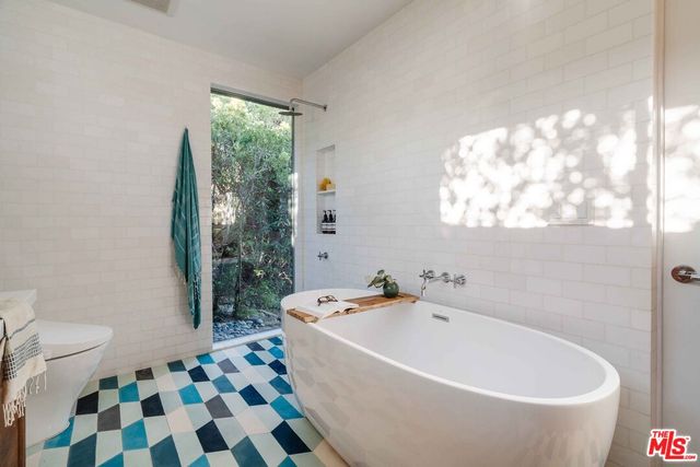 a white bath tub sitting next to a white toilet