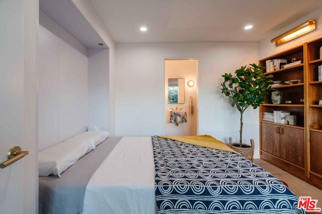 a bedroom with a bed and a plant