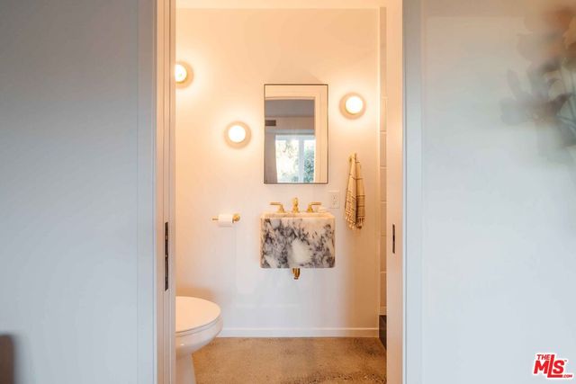 a bathroom with a toilet and mirror