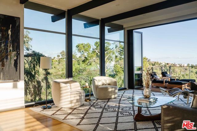 a living room with patio furniture and a floor to ceiling window