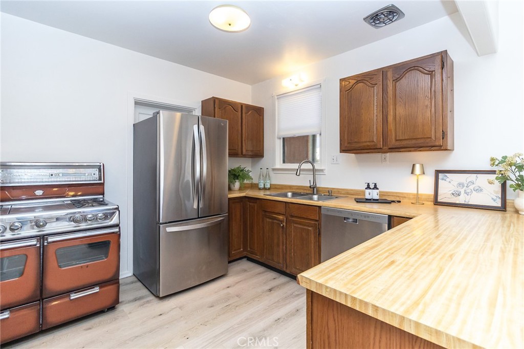 411 Bazoobuth Street Needles, CA 92363 - Photo 16 of 71 a kitchen with stainless steel appliances granite countertop a refrigerator stove and sink