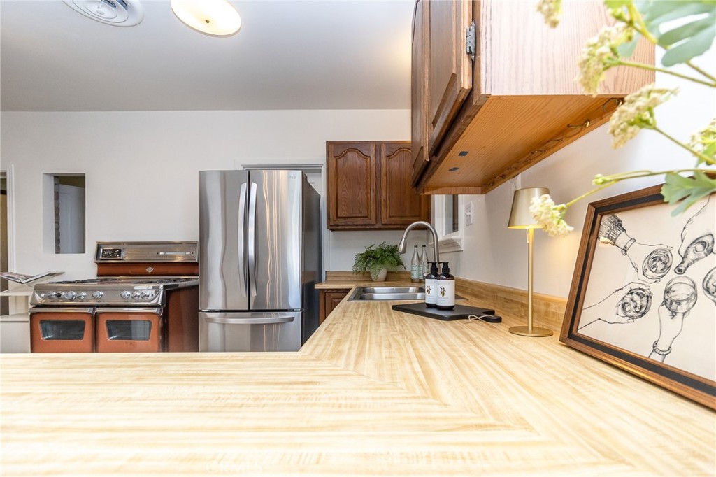 411 Bazoobuth Street Needles, CA 92363 - Photo 18 of 71 a kitchen with stainless steel appliances kitchen island granite countertop a refrigerator and a stove top oven