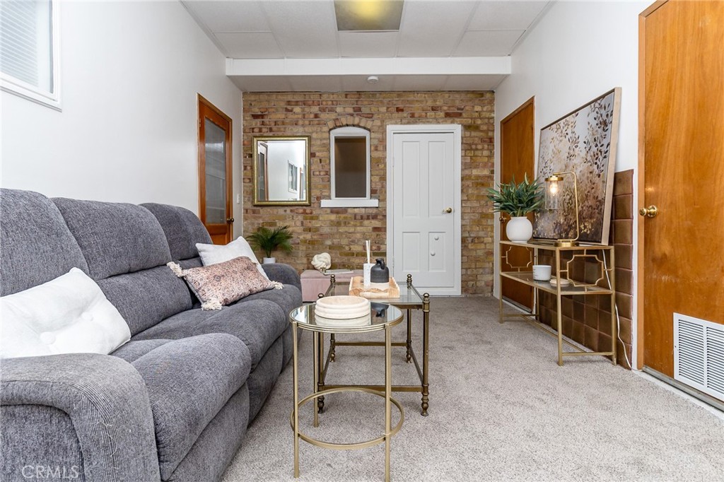 411 Bazoobuth Street Needles, CA 92363 - Photo 38 of 71 a living room with furniture a dining table and a potted plant