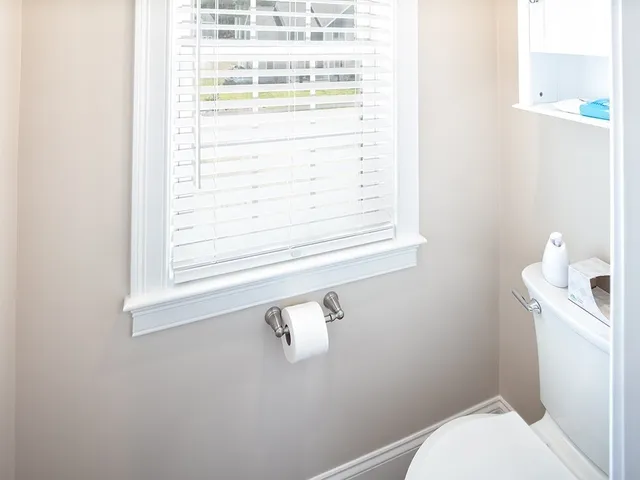 a bathroom with a window a toilet and a window
