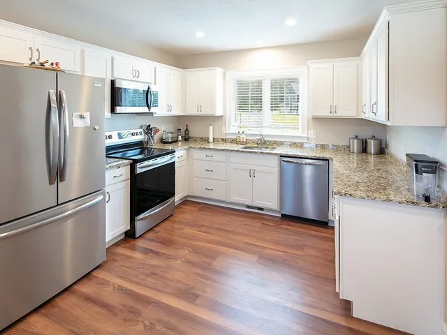 a kitchen with granite countertop stainless steel appliances a refrigerator sink and microwave