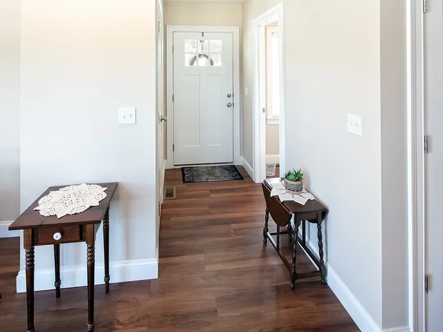 a view of a hallway with furniture and wooden floor