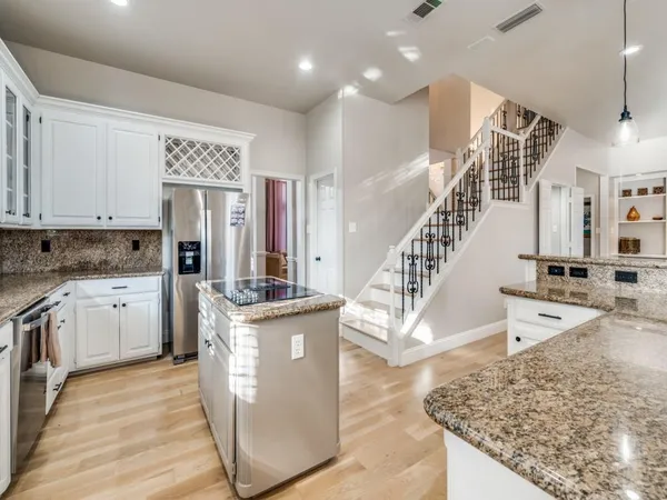 a kitchen with stainless steel appliances granite countertop a stove a sink and a refrigerator