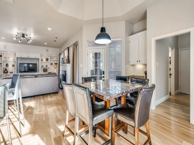 a view of a dining room and livingroom with furniture wooden floor a chandelier