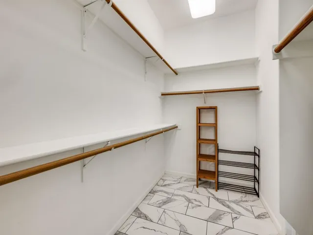 a view of walk in closet with empty racks