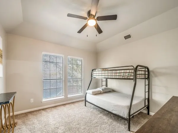 a bedroom with a bed and a ceiling fan