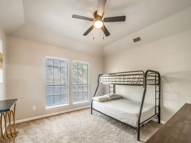 a bedroom with a bed and a ceiling fan