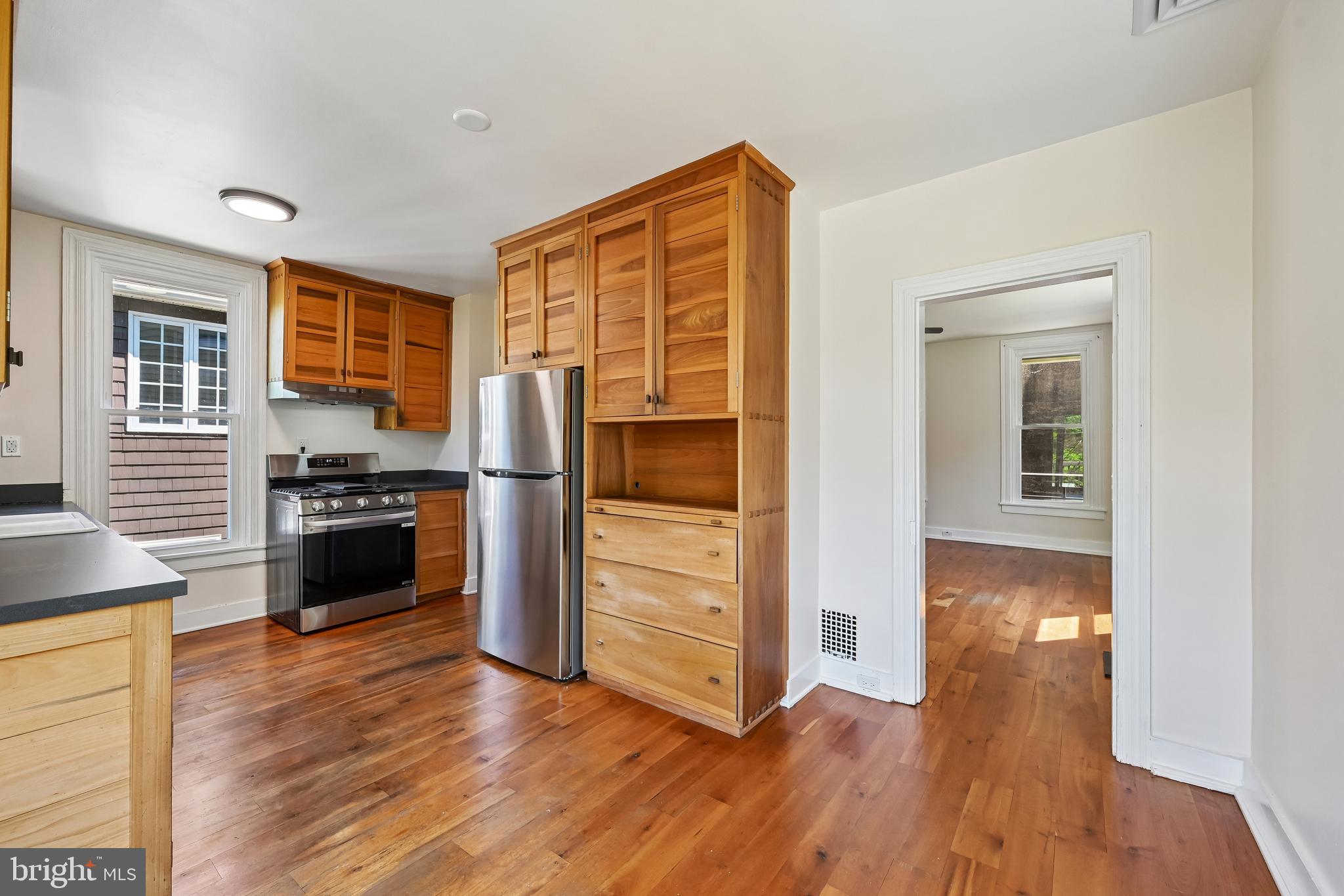 5702 Falls Road Baltimore, MD 21209 - Photo 12 of 49 a kitchen with wooden floors and refrigerator