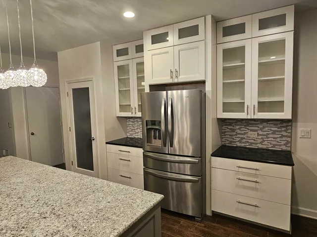 a kitchen with stainless steel appliances granite countertop a refrigerator and a stove top oven