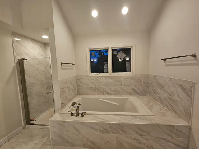 a bathroom with a bathtub and a shower