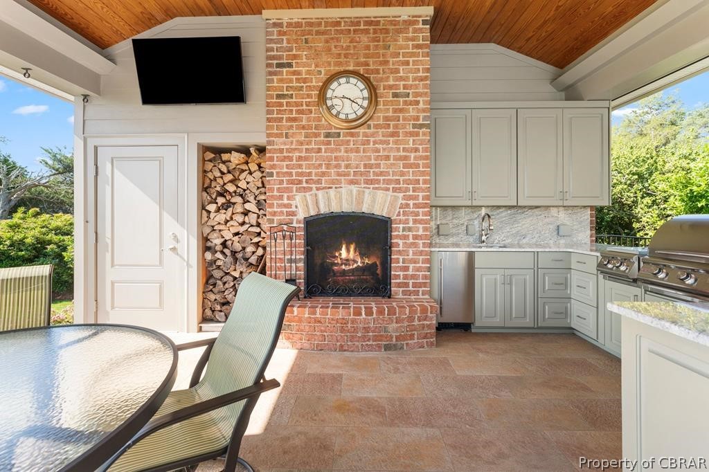 2055 Ditchley Road Kilmarnock, VA 22482 - Photo 8 of 48 View of patio with sink, exterior kitchen, area for grilling, and an outdoor brick fireplace