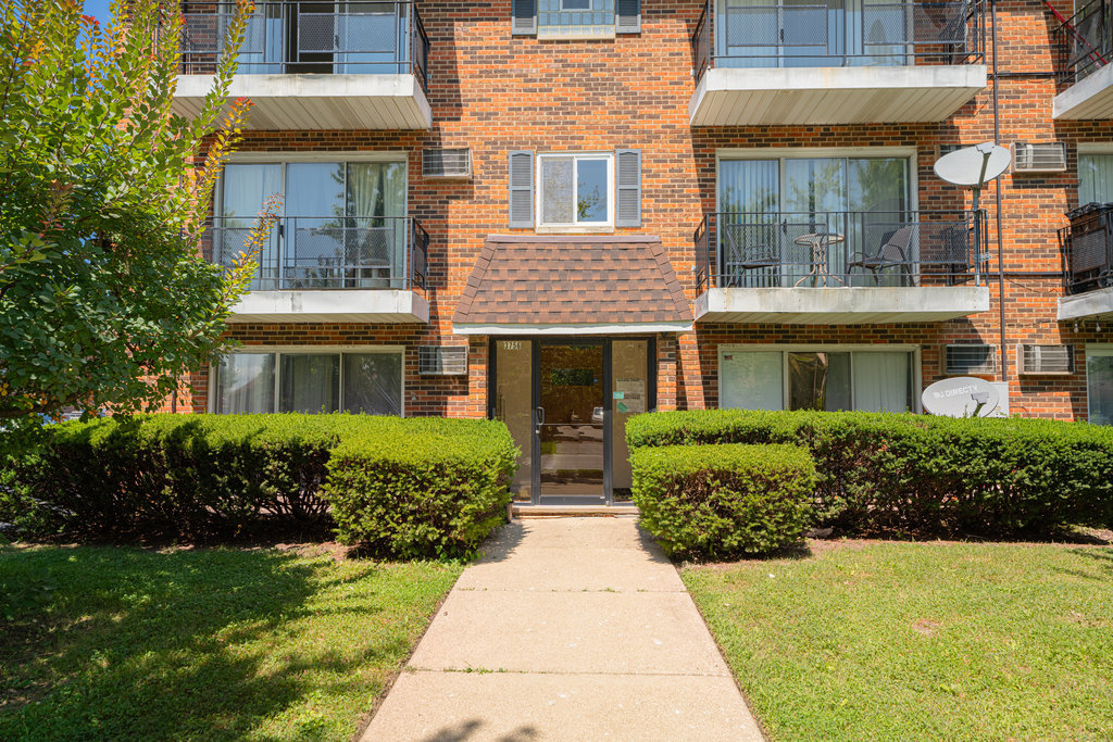 3756 West 120th Street, Unit 3A Alsip, IL 60803 - Photo 24 of 27 a front view of a brick house with a yard
