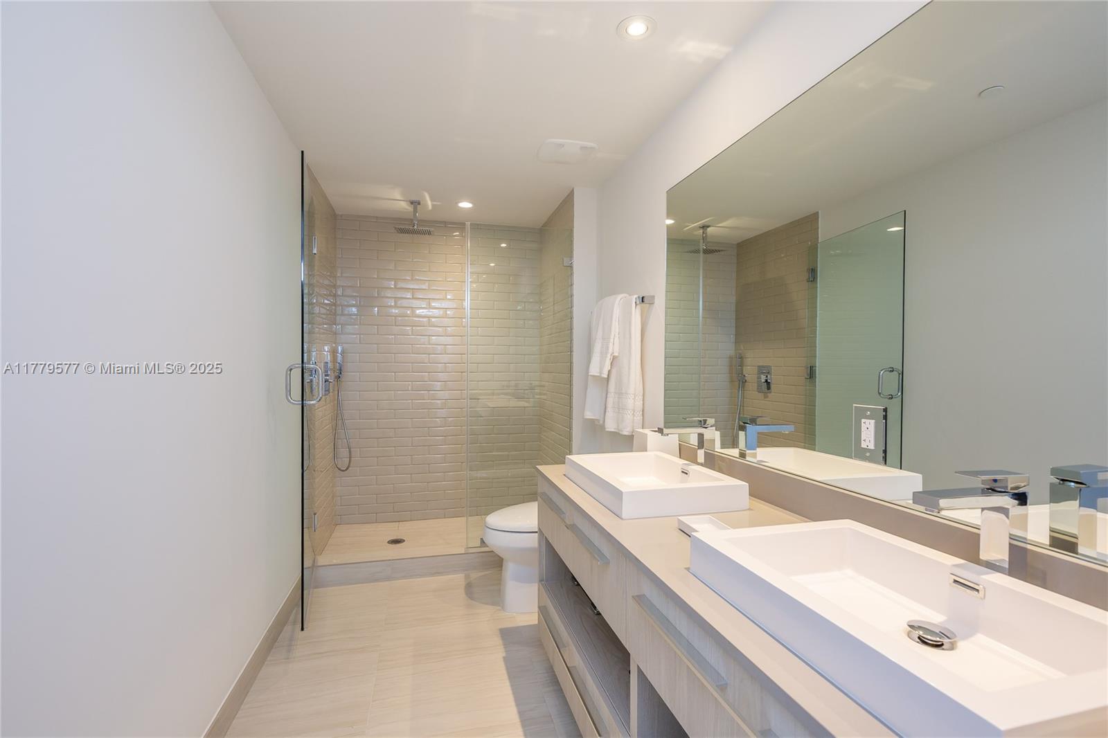 4010 South Ocean Drive, Unit R2204 Hollywood, FL 33019 - Photo 13 of 22 a bathroom with a double vanity sink toilet mirror and shower