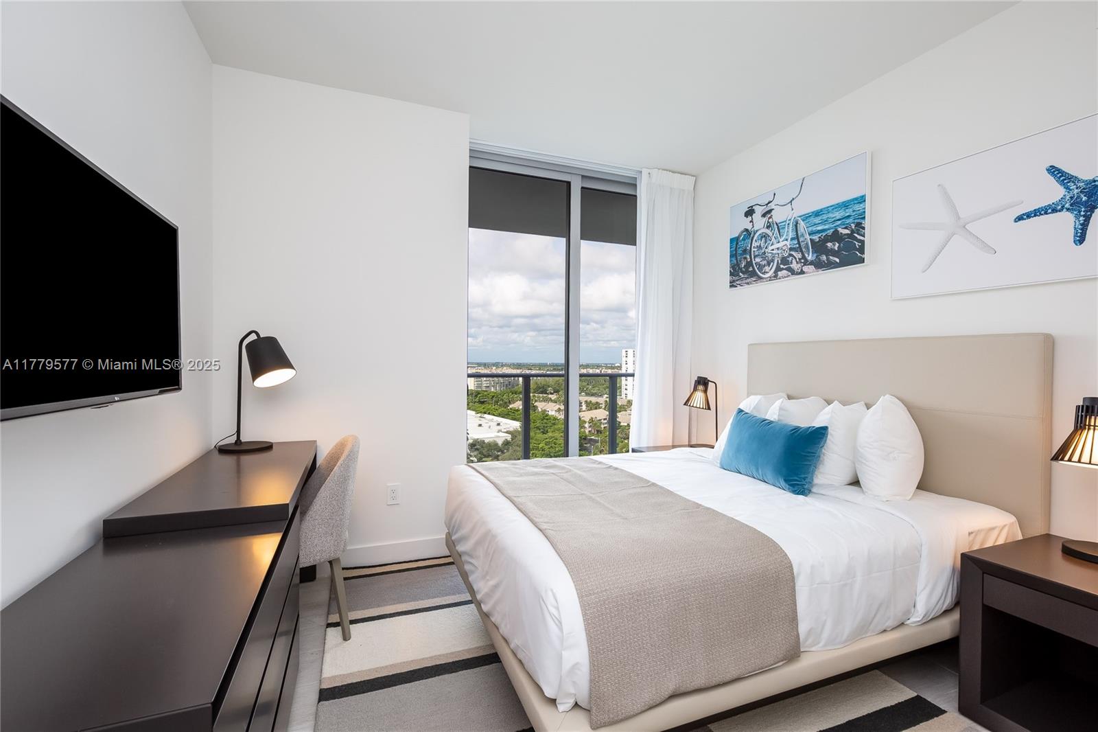 4010 South Ocean Drive, Unit R2204 Hollywood, FL 33019 - Photo 17 of 22 a bedroom with a bed and a flat tv screen on the dresser