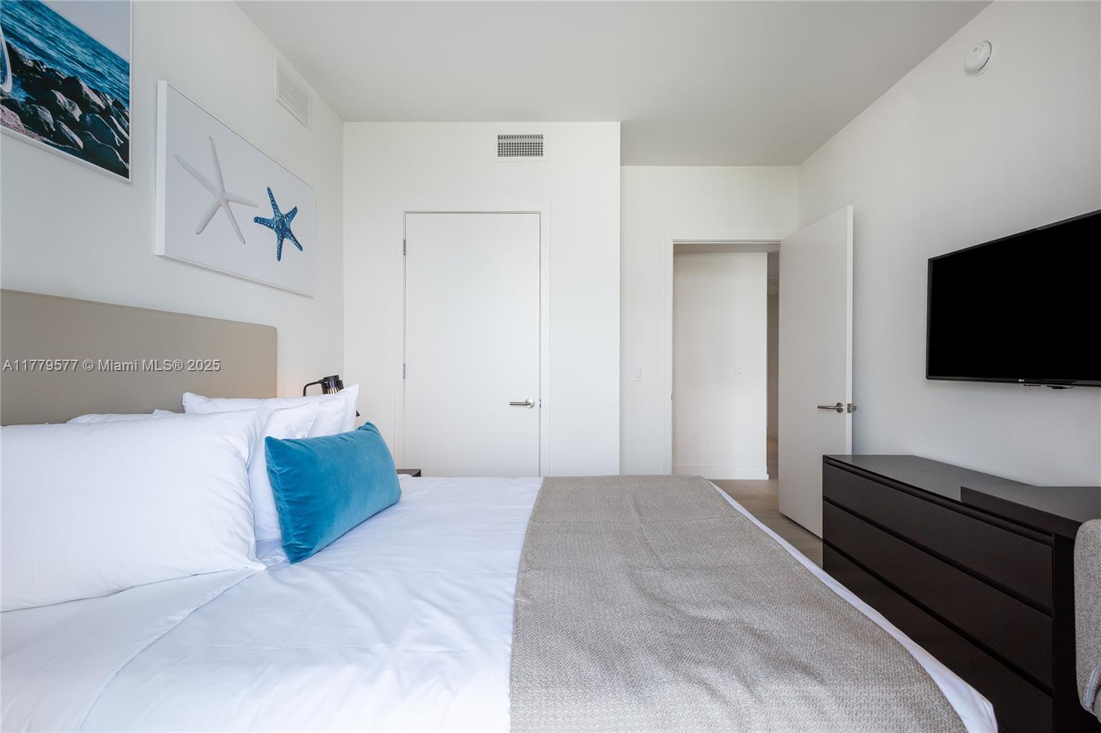 4010 South Ocean Drive, Unit R2204 Hollywood, FL 33019 - Photo 18 of 22 a bedroom with a bed and a flat screen tv