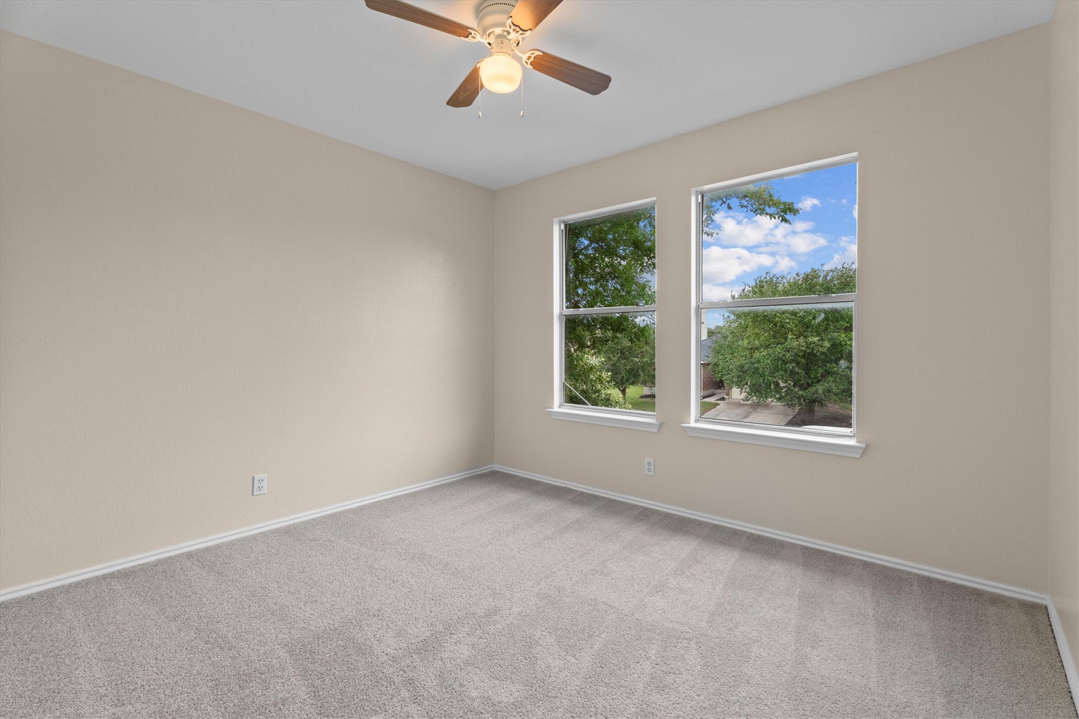 172 Discovery Kyle, TX 78640 - Photo 12 of 21 Bright secondary bedroom with soft carpet, ceiling fan, and large windows overlooking the neighborhood.