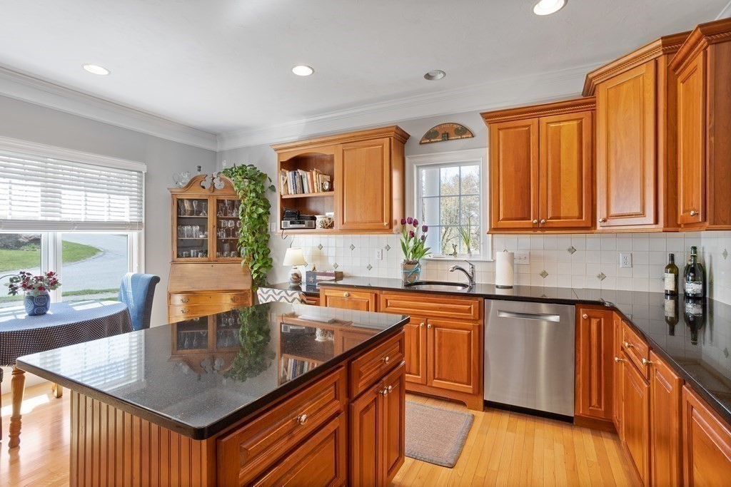 31 Sauta Farm Way, Unit 16 Hudson, MA 01749 - Photo 12 of 41 a kitchen with stainless steel appliances granite countertop wooden cabinets a sink a stove a dining table and chairs