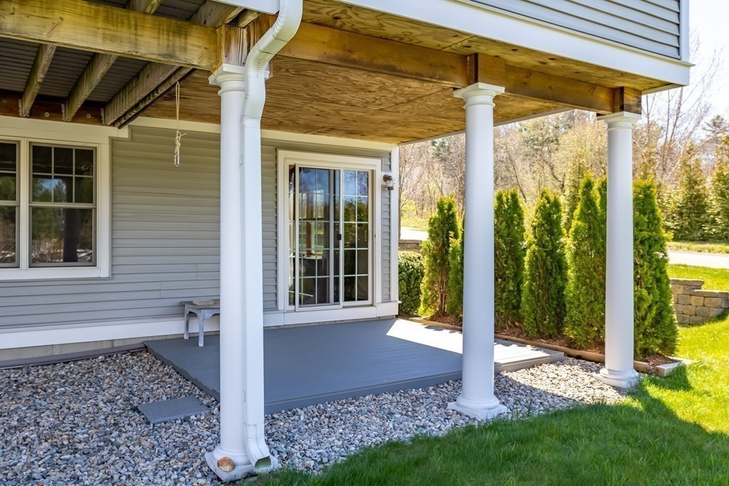 31 Sauta Farm Way, Unit 16 Hudson, MA 01749 - Photo 7 of 41 a view of a porch with a table and chairs and floor to ceiling window